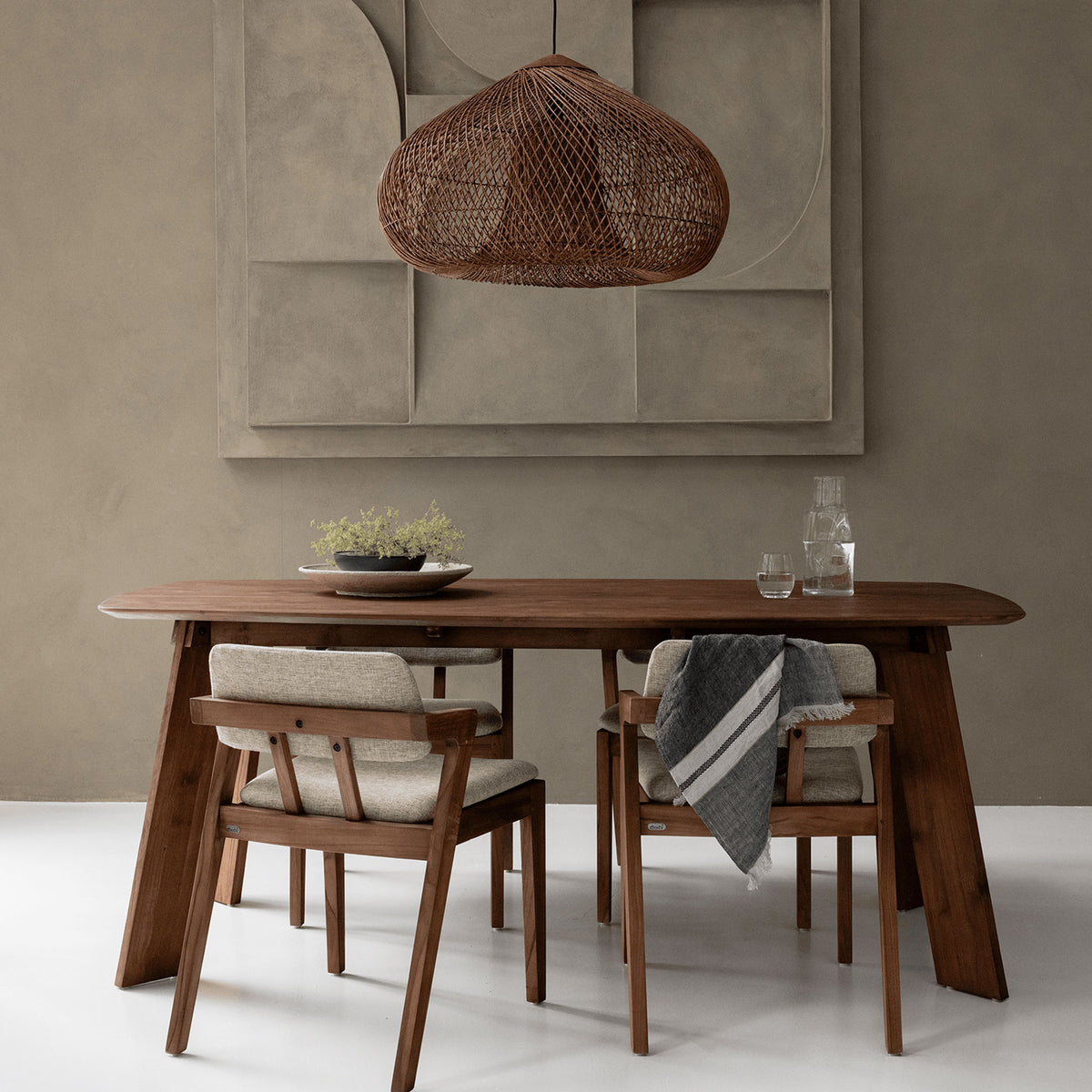 a wooden dining table and chairs in a room with a hanging rattan lampshade