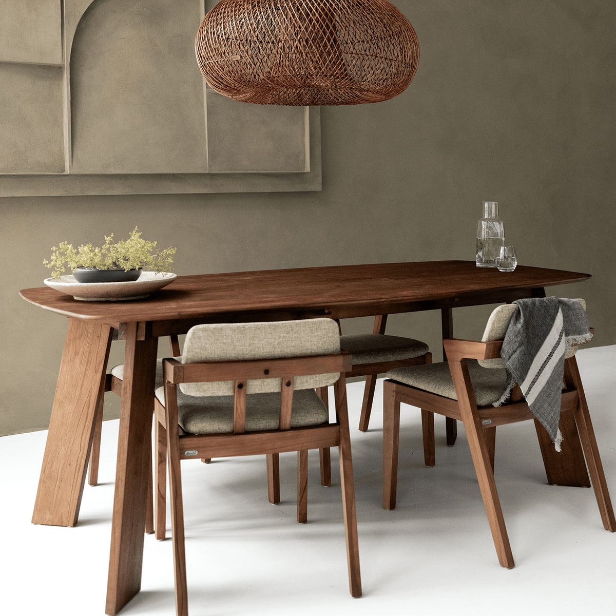 a wooden dining table and chairs in a room with a hanging rattan lampshade